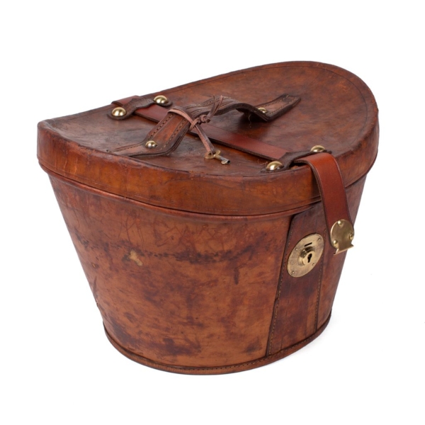 Hat box in Hazelnut cowhide with handle lid and lock hose and interior in burgundy velvet.