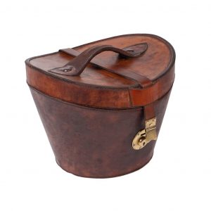 Hazelnut-colored cowhide hat box, lid with handle and non-existent locking key. Interior in burgundy satin.