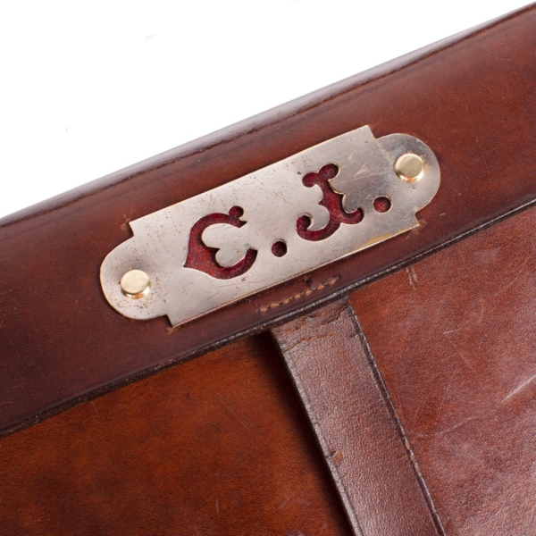 Leather hunting shoulder bag with metal plate with the initials C.J. Lid with lock with a rifle holder latch.