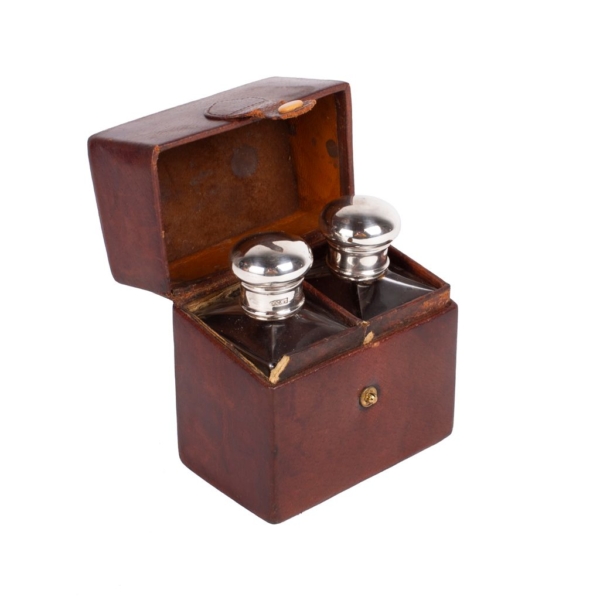 Fitted leather cologne box with glass bottles with silver and punched stoppers. Accessories and complements.