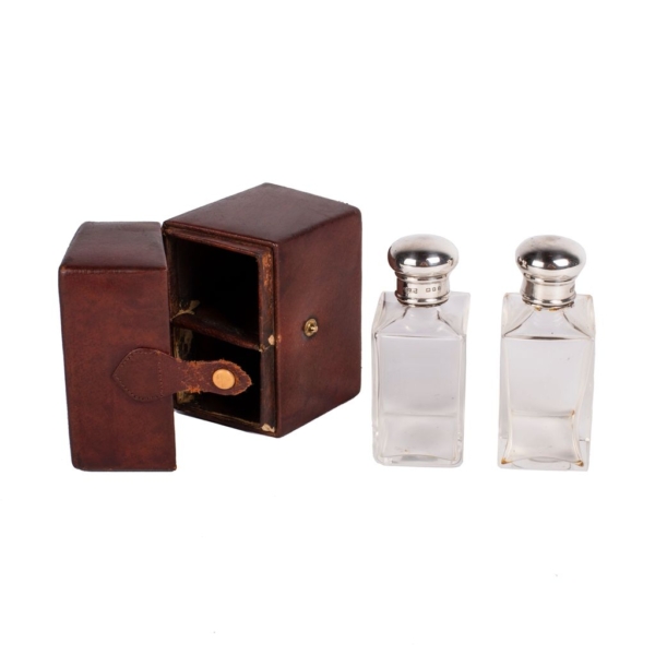 Fitted leather cologne box with glass bottles with silver and punched stoppers. Accessories and complements.