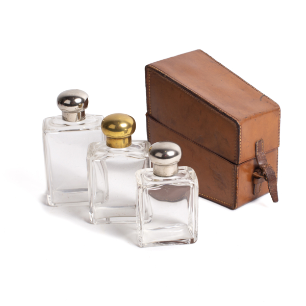 Perfume boxes with three decreasing bottles and leather case.